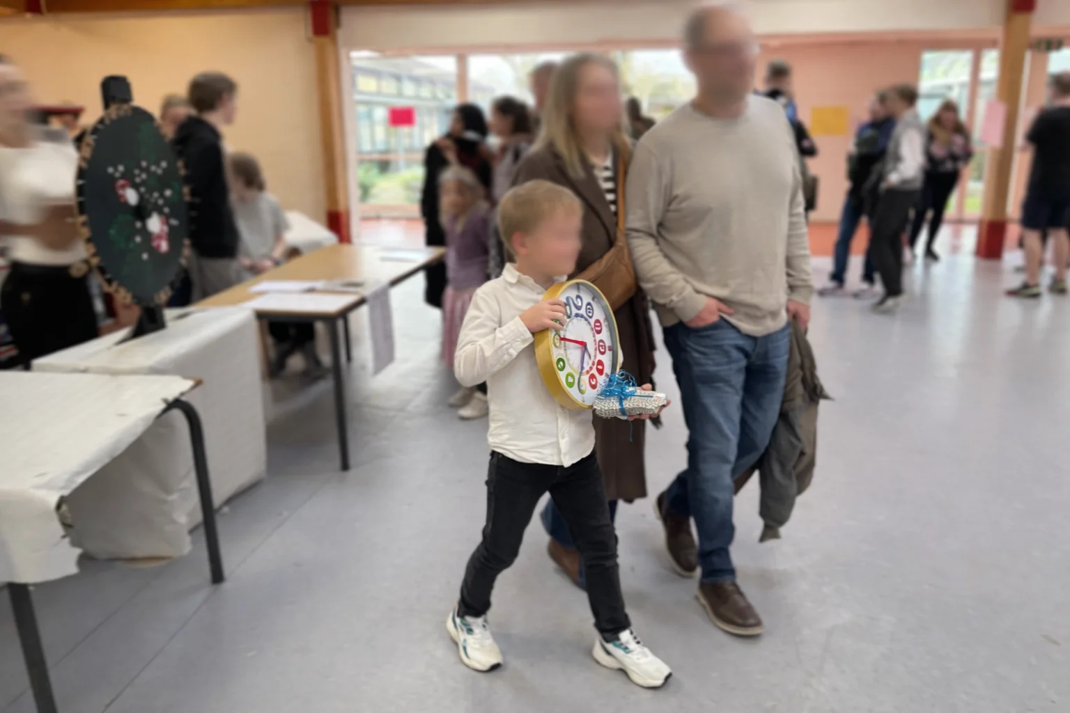 Dreng med familie vinder læringsur fra SkoleABC.dk ved lykkehjul på skolefest på Haarby Skole